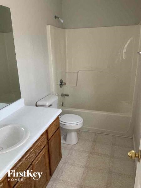 A bathroom with a toilet, sink, and shower.
