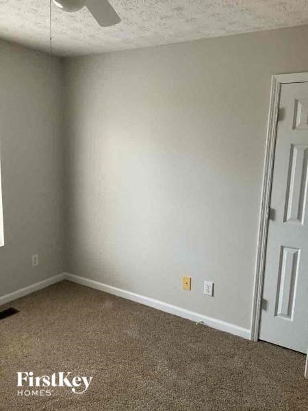 A room with a carpeted floor and a door.