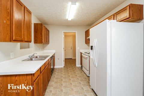 a kitchen with white appliances and wooden cabinets