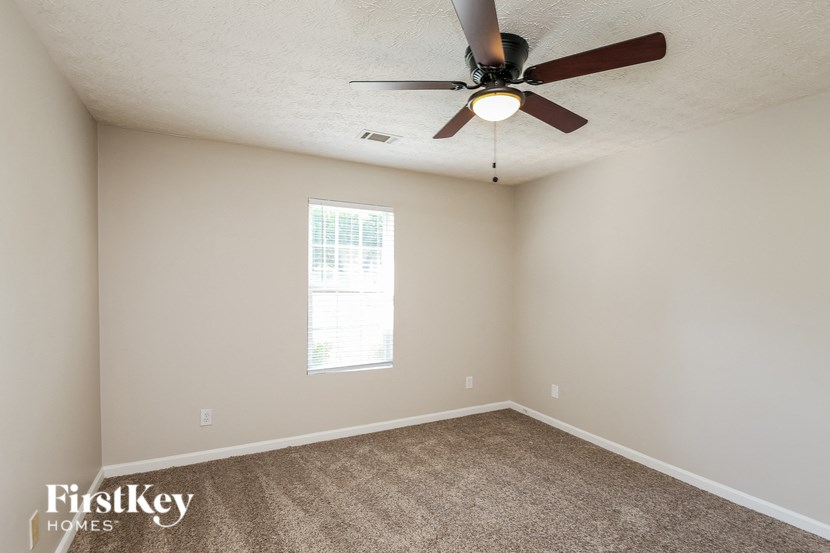 a bedroom with a ceiling fan and a window