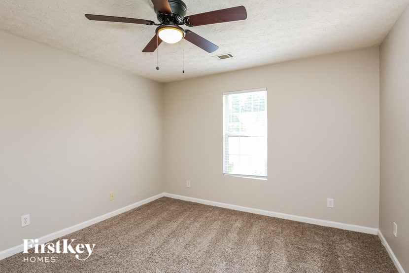 a bedroom with a ceiling fan and a window