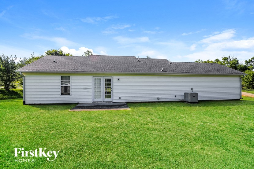 a white house with a grassy yard and a blue sky