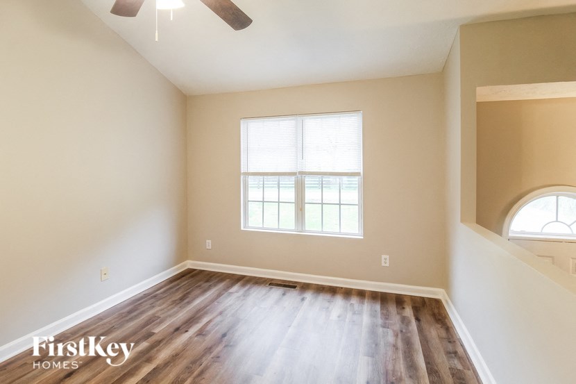 an empty living room with hardwood floors and a window
