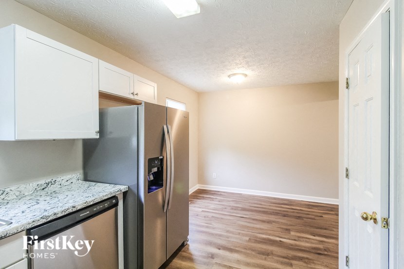 a renovated kitchen with stainless steel appliances and white cabinets