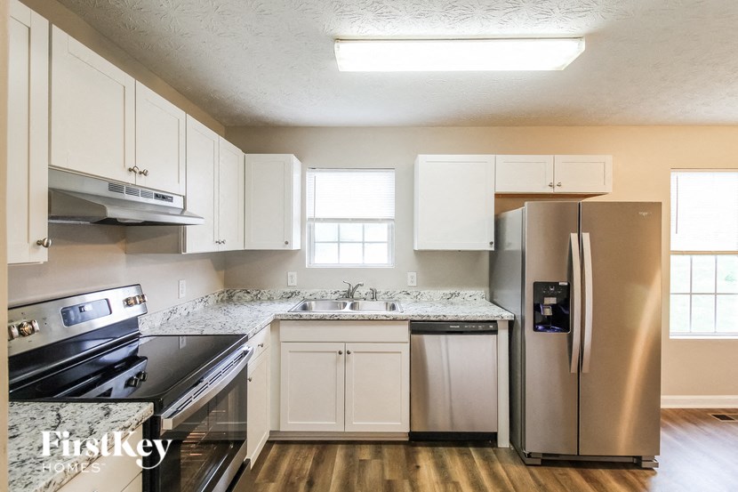 a kitchen with white cabinets and stainless steel appliances