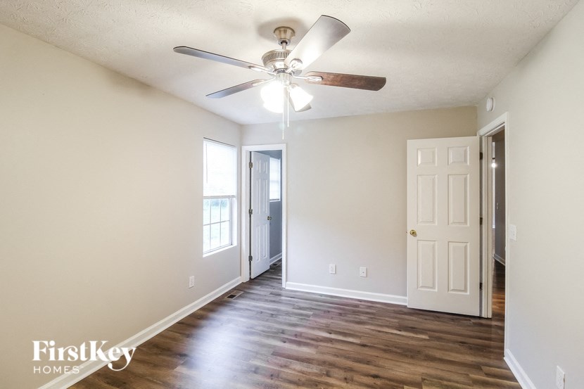 a living room with wood floors and a ceiling fan