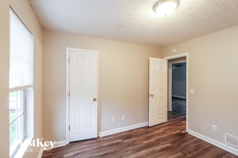 a living room with two doors and a door to a hallway