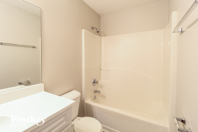 a white bathroom with a tub and a sink and a toilet