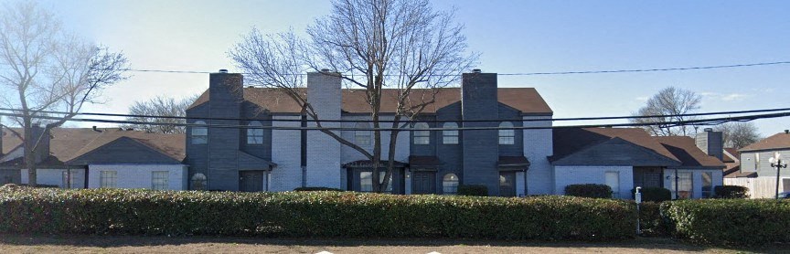 a large white house with a fence in front of it