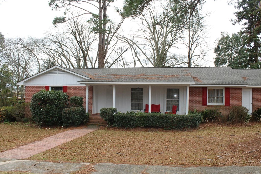 a house with red chairs in the front yard