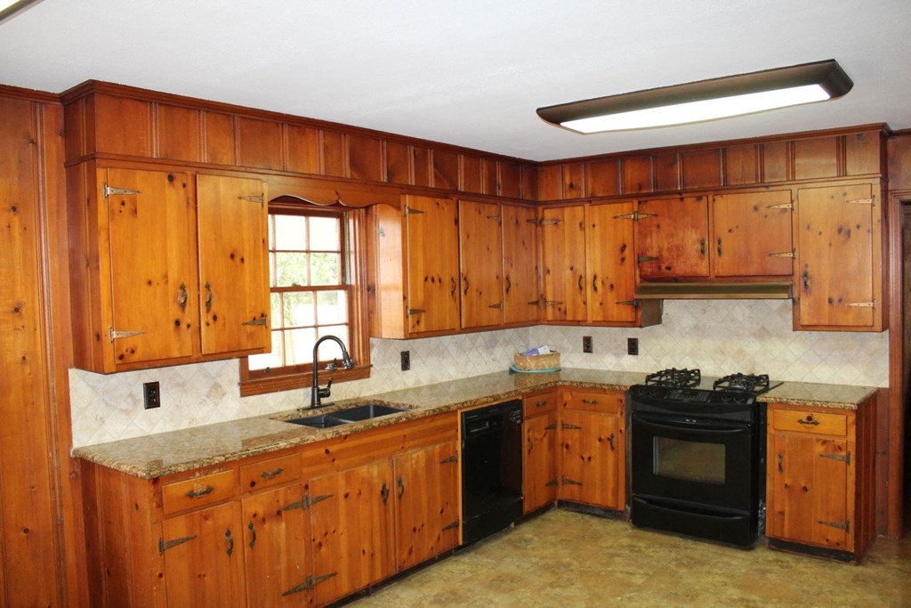 a kitchen with wooden cabinets and black appliances
