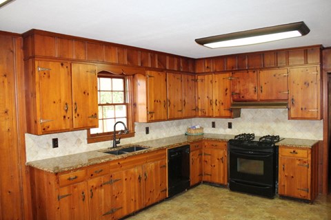 a kitchen with wooden cabinets and black appliances