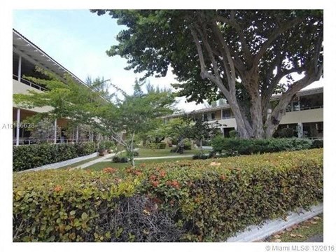 a view of a building with trees and bushes
