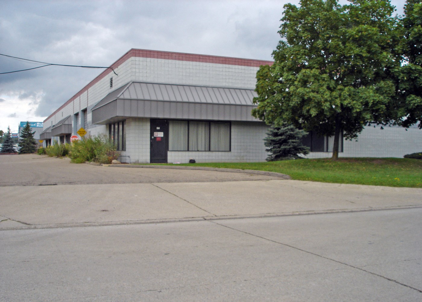 a white building with a red roof next to a street