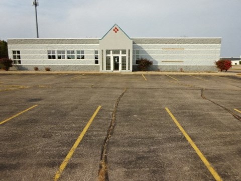 A white building with a red triangle on the top left corner.