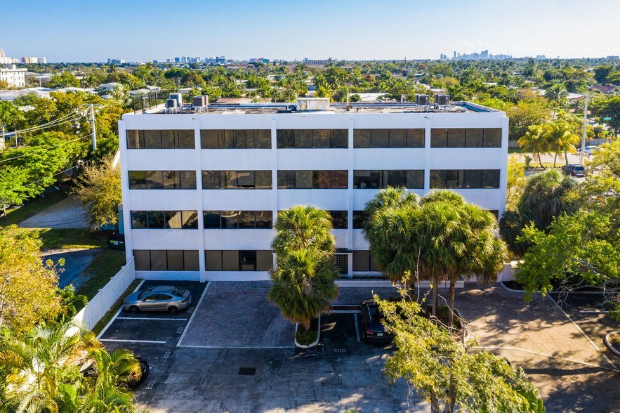 a large white office building with palm trees in front of it