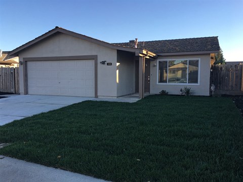A house with a white garage door and a brown roof.