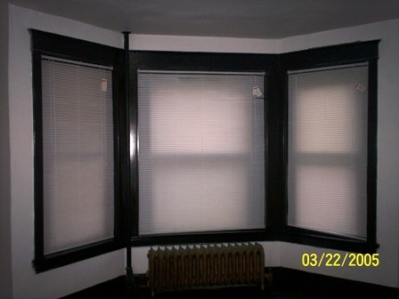 a room with three windows and a radiator