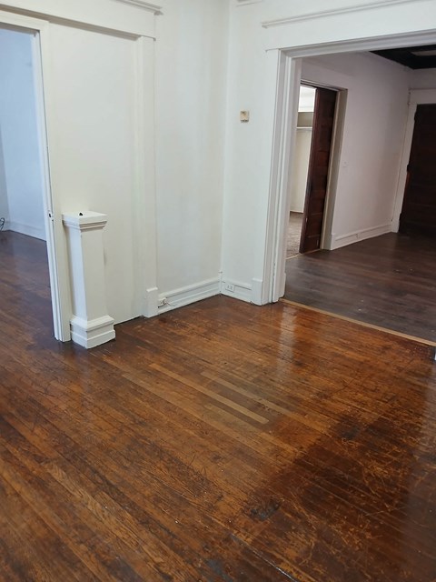 A room with a wooden floor and white walls.