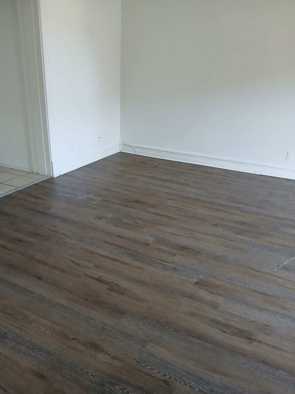a room with a wooden floor and a white wall