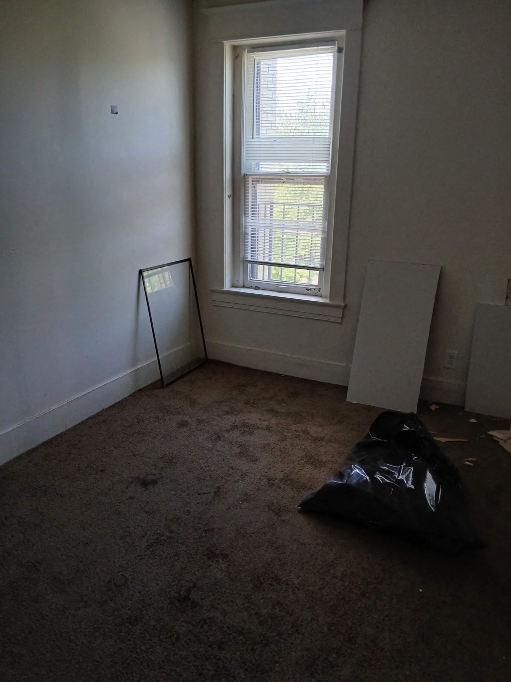 a room with a window and a black bag on the floor