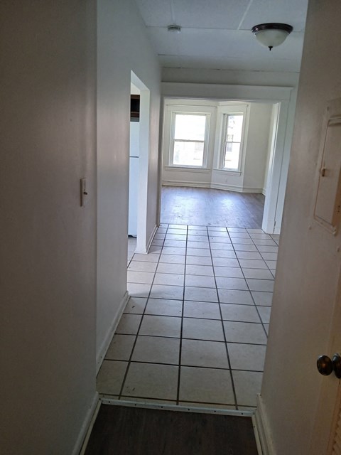 an empty room with a tiled floor and a window