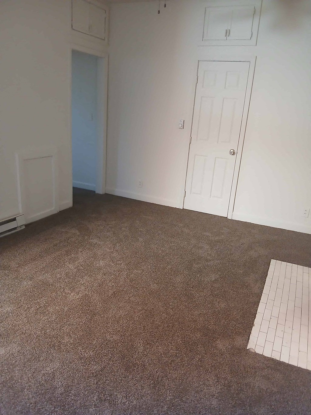 a room with a carpeted floor and a white door