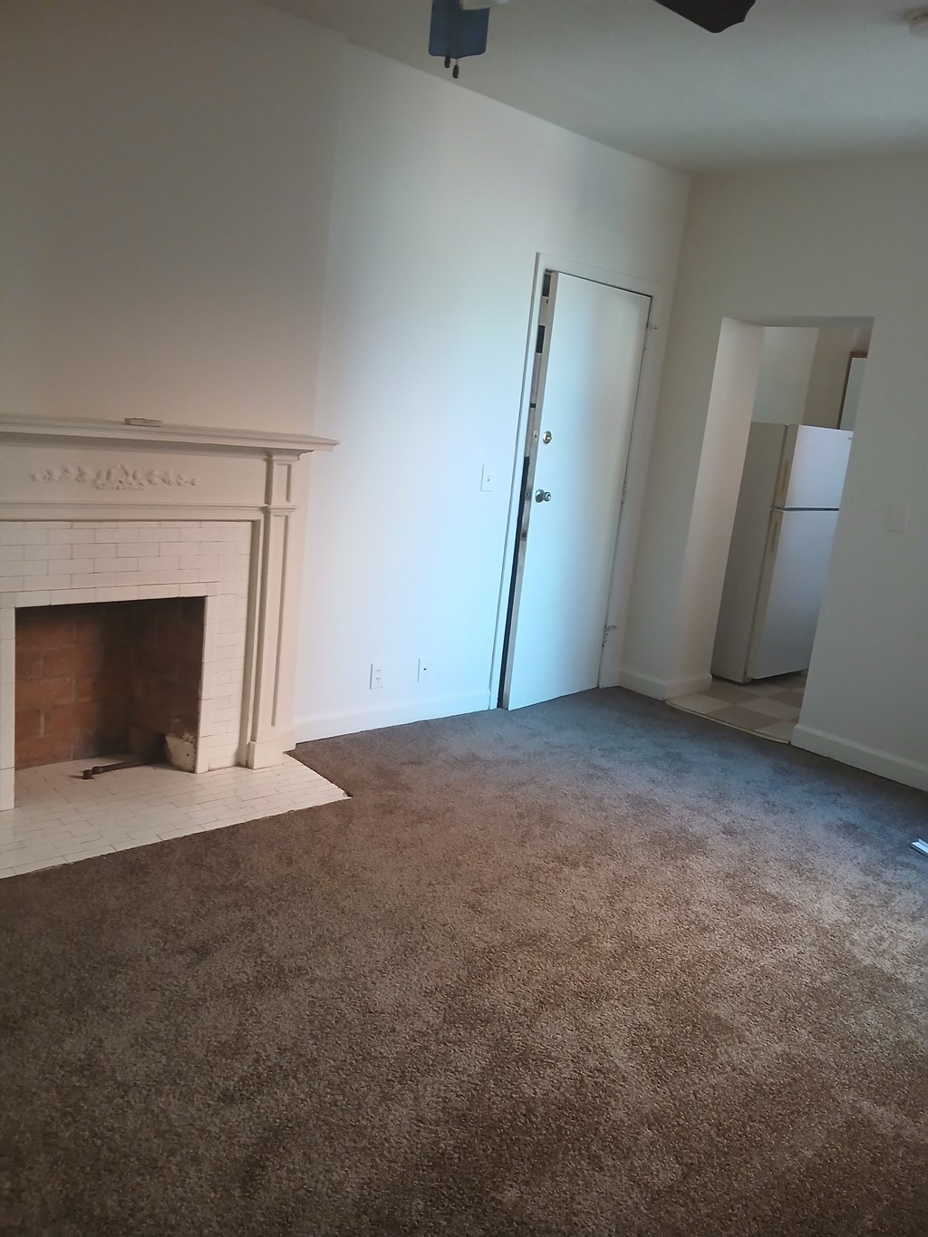 an empty living room with a fireplace and a closet