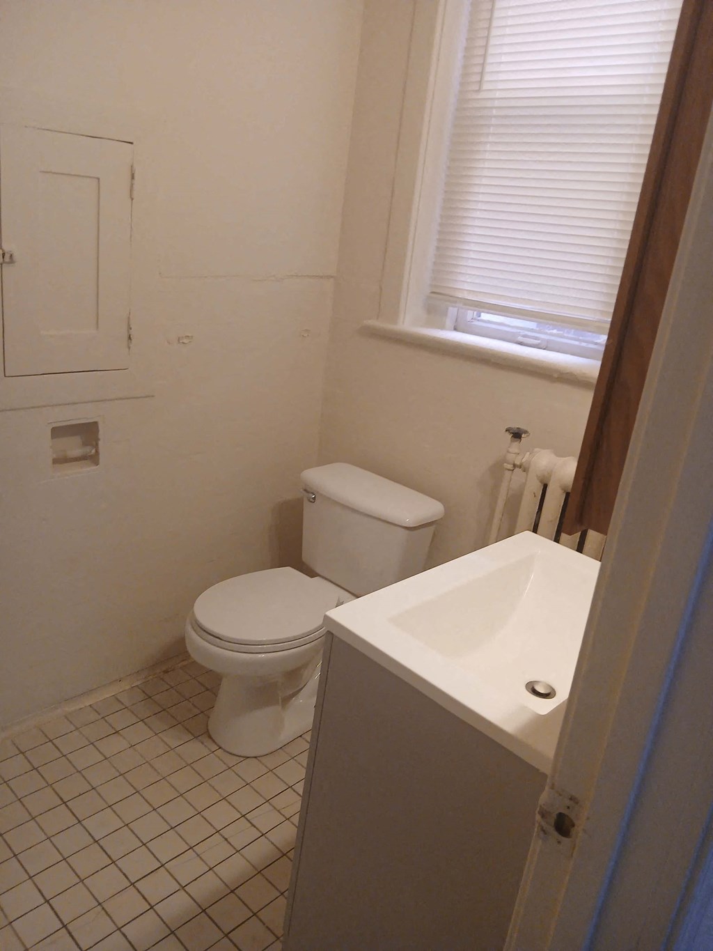 a bathroom with a toilet and a sink and a window