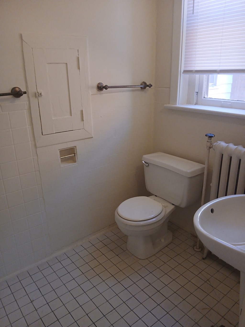 a bathroom with a toilet and a sink and a window