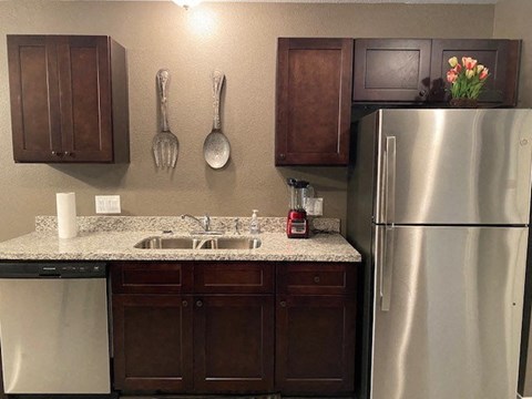 a kitchen with a stainless steel refrigerator and a sink