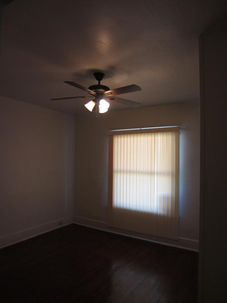 a living room with a ceiling fan and a window