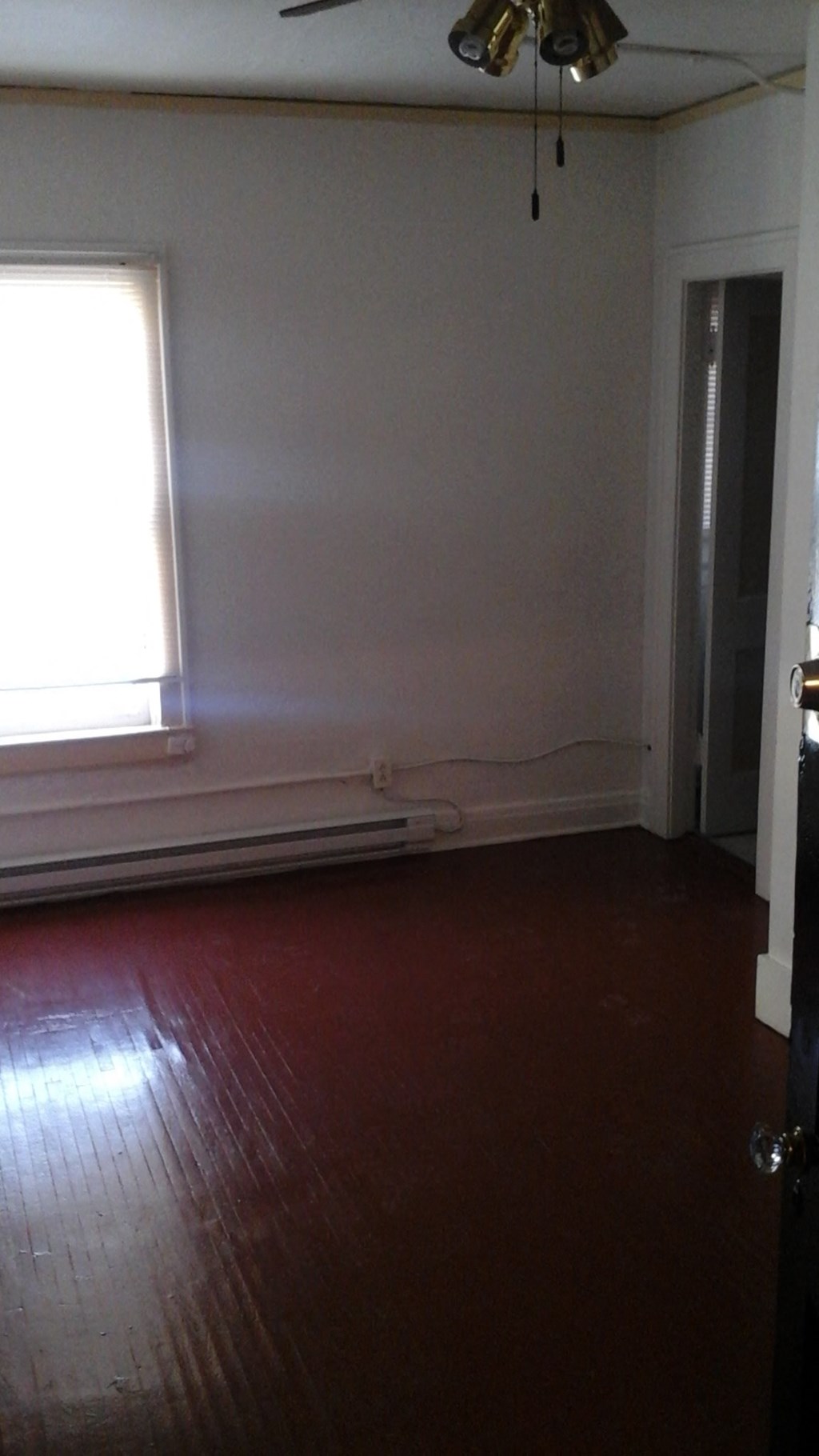 an empty room with a wood floor and a window