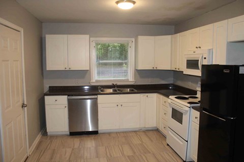 A kitchen with white cabinets and black appliances.