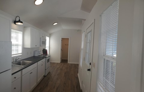 A kitchen with white cabinets and a sink.