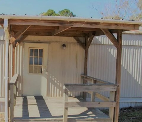 A small wooden structure with a porch and a table.