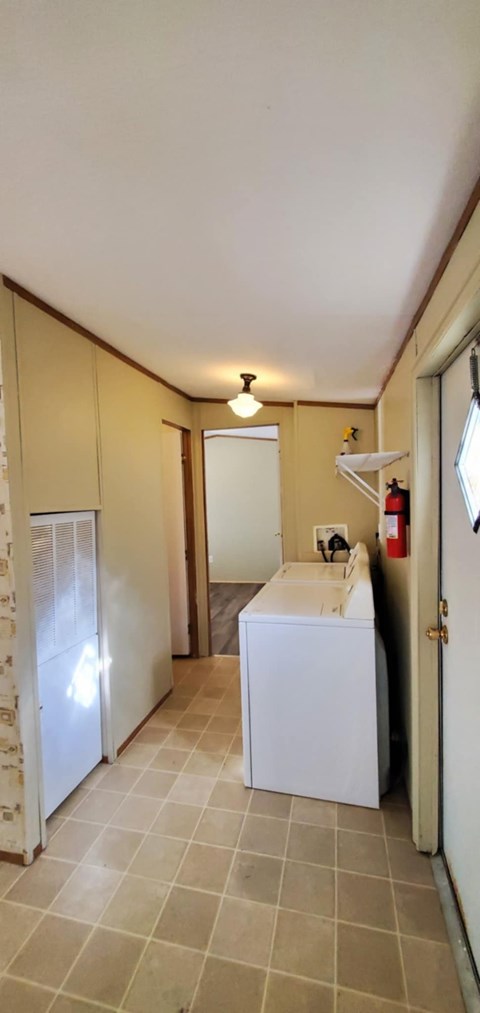A kitchen with a white fridge and a white sink.