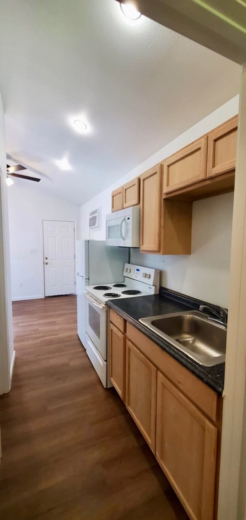 A kitchen with wooden cabinets and a stove top oven.