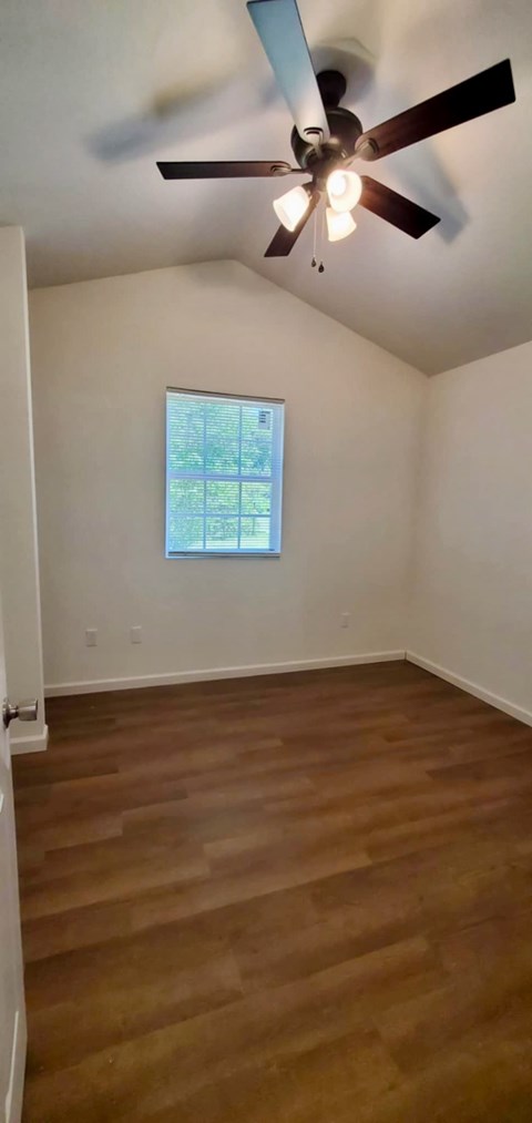 A room with a ceiling fan and a window.