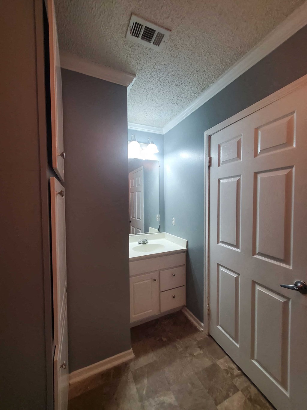 a bathroom with a white sink and a white door
