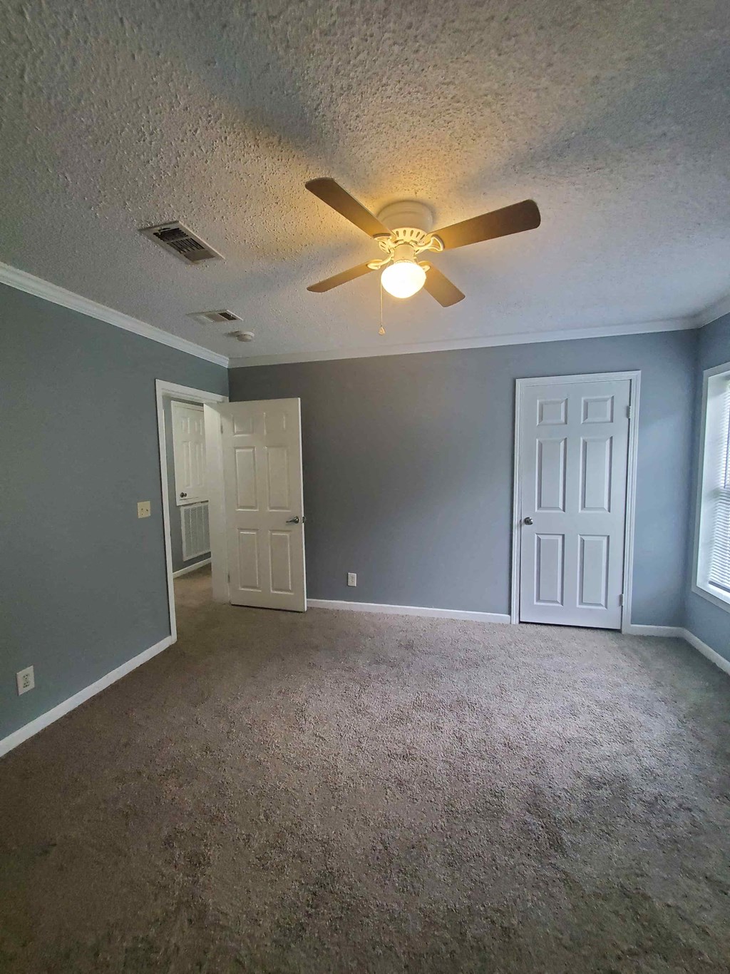 a empty living room with a ceiling fan