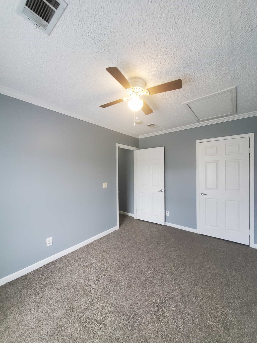 an empty living room with a ceiling fan