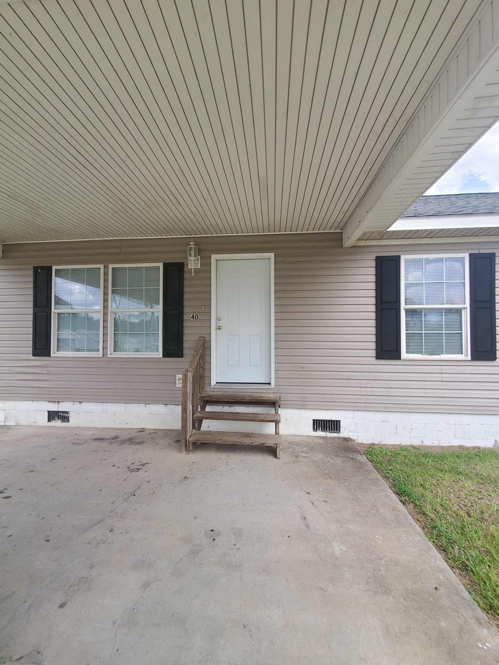 the front of a house with a porch and a white door