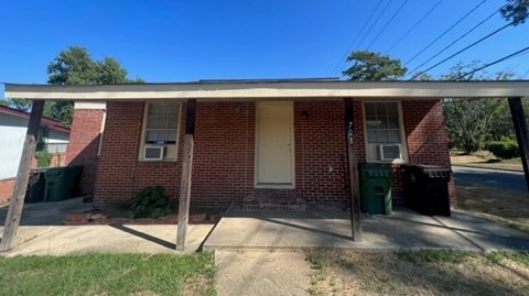 A red brick house with a white door and windows.