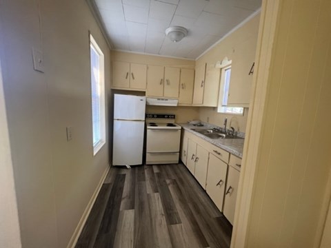 A kitchen with a white refrigerator, white oven, and white cabinets.
