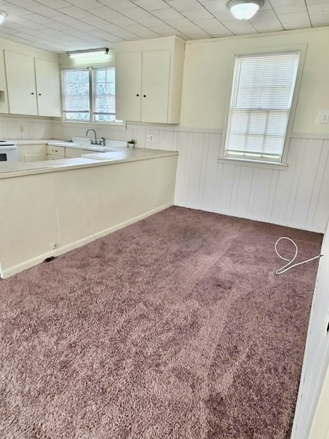 A kitchen with white cabinets and a sink.