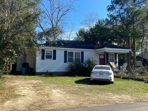 a white house with a white car parked in front of it