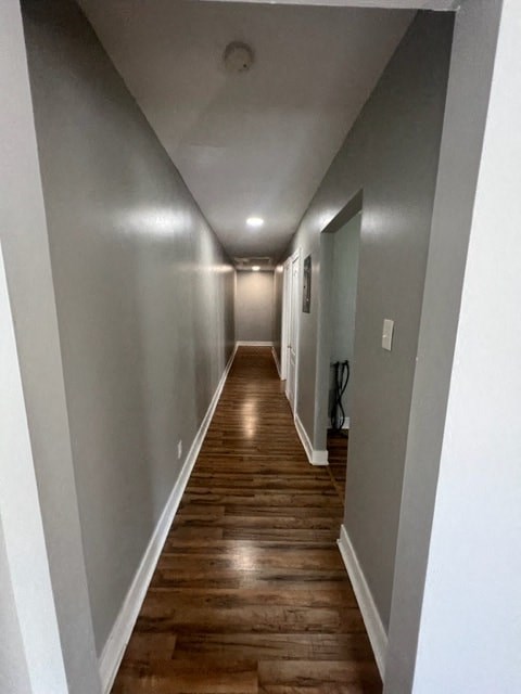 a hallway with wooden floors and grey walls and a white ceiling