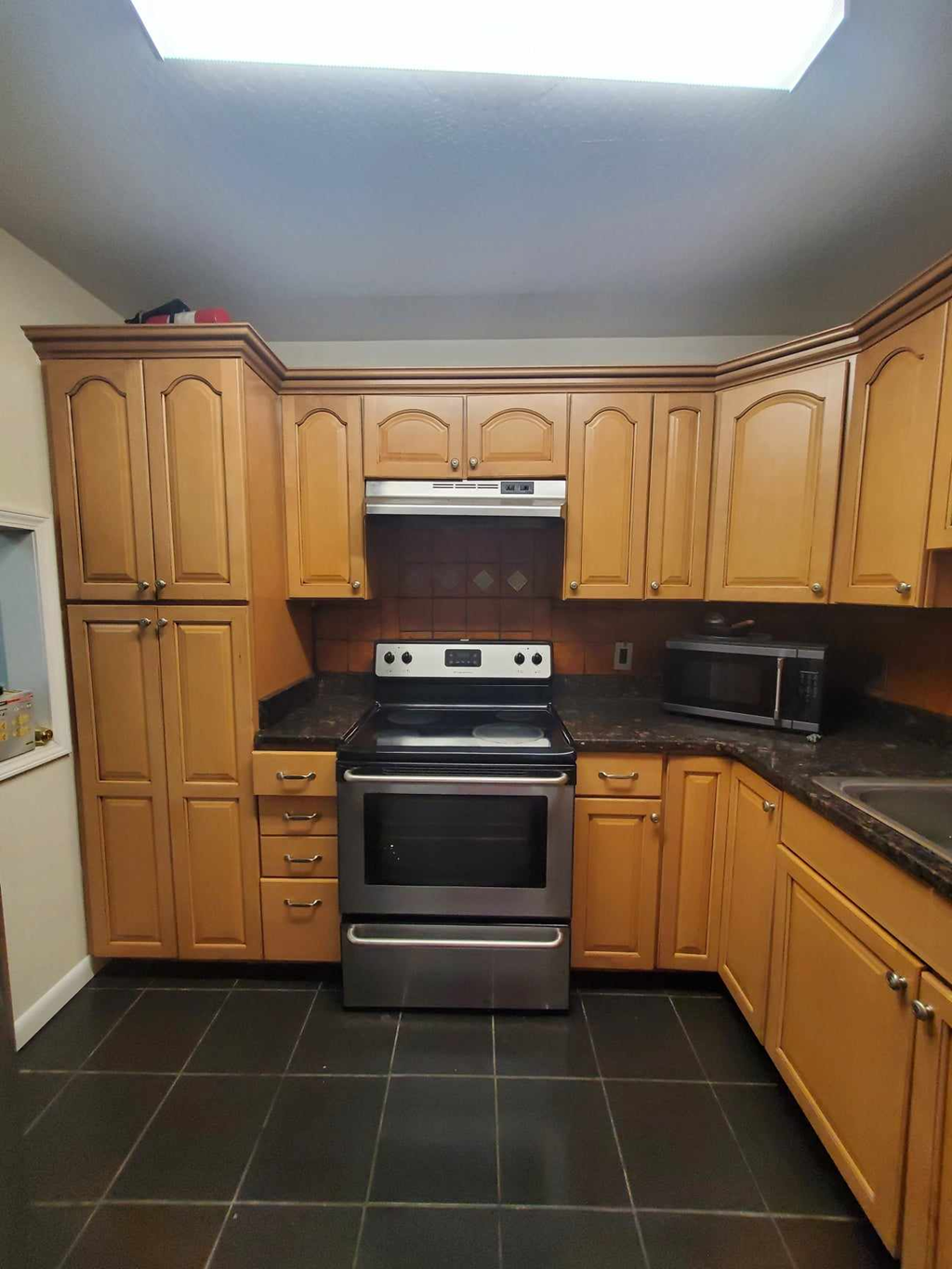 a kitchen with wooden cabinets and a stove