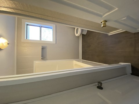 a bathroom with a bath tub and a sink and a window